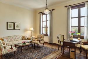 a living room with a couch and chairs and a table at Maidens Hotel New Delhi in New Delhi