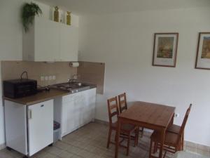 a kitchen with a table and a table and chairs at Remser Haus in Zalakaros