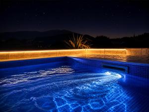 a swimming pool at night with blue lighting at Villa Lumia in Banjol