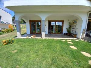 a white house with a yard with a grass field at Casa Orchidea in Aggius