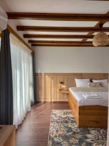 a bedroom with a bed and a large window at Братановите Къщи in Dŭbravka +43 photos