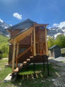 a log cabin with a staircase leading to the porch at Bujtina Diti in Tropojë