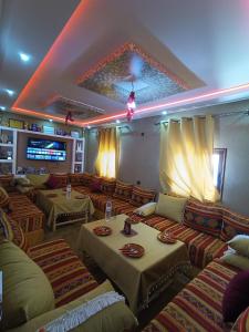 a living room with couches and tables in a room at Toubkal Guesthouse in Imlil