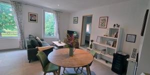 a living room with a table and green chairs at Maison de la Craffe in Francs