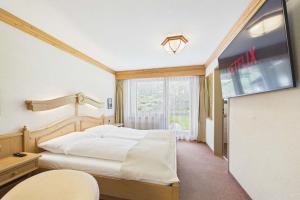 a bedroom with a large bed and a window at Suite with Mountain View near Saas-Fee in Saas-Almagell