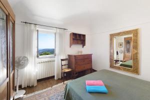 a bedroom with a bed and a mirror and a window at Villa Ponzio in Genoa