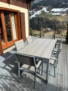 a wooden table and chairs on a deck at Chalet Cocoon in Val-d'Illiez