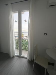 a white room with a window and a table and chair at B & B Yaya in Taranto