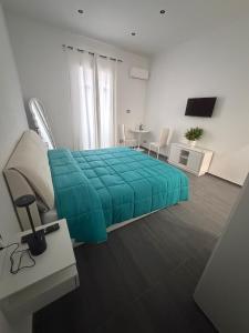 a bedroom with a green bed and a table at B & B Yaya in Taranto