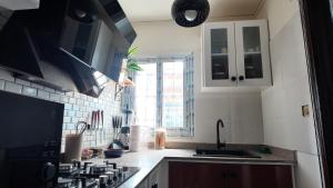 a kitchen with black and white cabinets and a sink at 'Belkaz in Port-Gentil