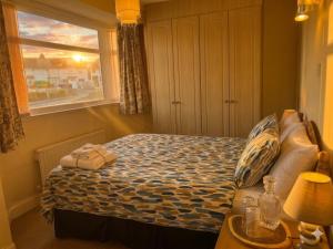 a small bedroom with a bed and a window at Tharsh Peaceful Escape Double Room with Shared Bathroom in Coundon