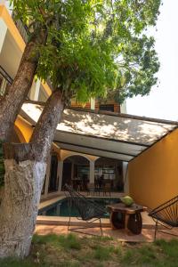 Ein Tisch und Stühle unter einem Baum neben einem Haus in der Unterkunft Hotel Jabal Inn in Tixmucuy