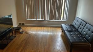 a living room with a couch in a room with wooden floors at Stoners Sanctuary in Detroit