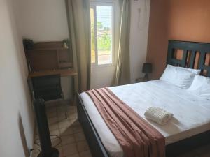 a bedroom with a bed and a window at 'Belkaz in Port-Gentil