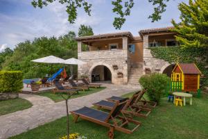 a group of lounge chairs in front of a house at Casa Karnevali in Žminj