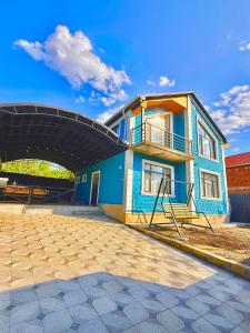 a blue building with a balcony on the side of it at Quba Villa in Quba