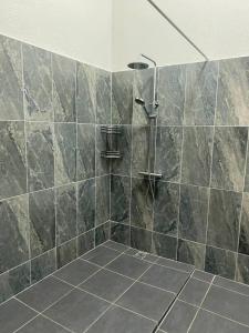 a bathroom with a shower with a stone wall at GRAND Restaurant&Hotel in Daugavpils