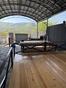 a large patio with a table on a wooden floor at Quba Villa in Quba +8 photos