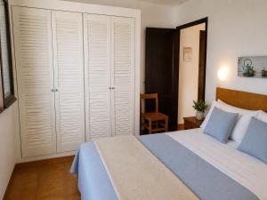 a bedroom with a large bed with blue pillows at Sa Cala C16 in Cala Morell