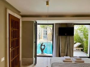 a bedroom with a bed and a tv and a pool at Thirty8 Heritage House in Chania