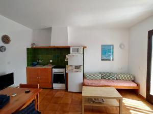 a small kitchen with a couch and a refrigerator at Sa Cala C16 in Cala Morell