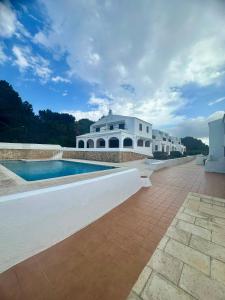 a large white house with a swimming pool at Sa Cala C16 in Cala Morell