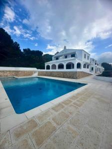 a large white house with a swimming pool at Sa Cala C16 in Cala Morell +7 photos