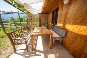 a table and chairs on the porch of a house at Sweet Bee Cottage in Bovec