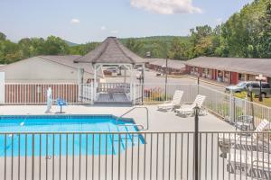 una piscina con recinzione e sedie e un edificio di Hotel Express Anniston/Oxford ad Anniston