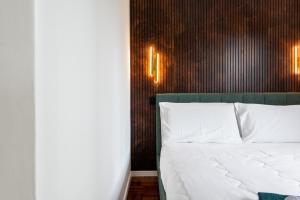 a bedroom with a white bed and a wooden wall at Cozy Loft near MXP AIRPORT & RHO FIERA - 4 GUESTS - Parking FREE in Legnano