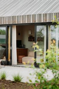 a house with glass doors and a living room at Boshuis Haen in Ermelo
