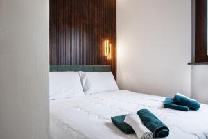 a white bed with two towels on top of it at Cozy Loft near MXP AIRPORT & RHO FIERA - 4 GUESTS - Parking FREE in Legnano