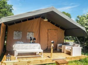 a large tent with a bed and a table at Ingerichte safaritent in Saint-Priest-en-Murat
