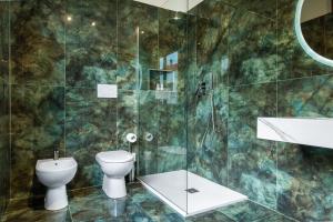 a bathroom with a toilet and a glass shower at Cozy Loft near MXP AIRPORT & RHO FIERA - 4 GUESTS - Parking FREE in Legnano