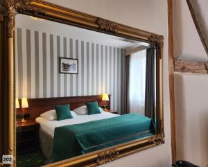 a hotel room with a bed and a mirror at City Hotel Morris in Česká Lípa
