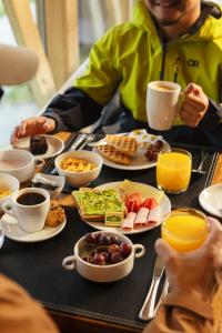 a table topped with plates of breakfast foods and drinks at Hostal Boutique Factoria Patagonia in Puerto Natales +37 photos