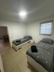 a bedroom with two beds and a window at FEWO Lohmar in Lohmar