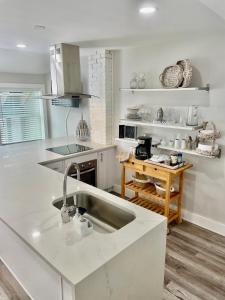 a white kitchen with a sink and a counter at Lil' Beach Getaway in Jacksonville Beach +4 photos