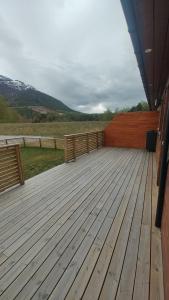 a large wooden deck with a view of a field at Signegarden Bismo in Skjåk