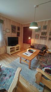 a living room with a table and a tv at Signegarden Bismo in Skjåk