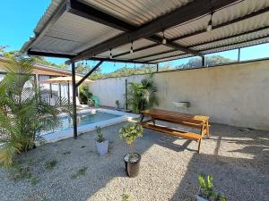 a patio with a wooden bench and a pool at Casa Congo Puerto Viejo in Puerto Viejo