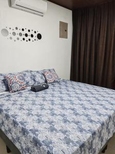 a bed with a blue and white comforter and pillows at Casa Congo Puerto Viejo in Puerto Viejo +16 photos