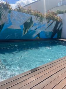 a swimming pool with a mural on the side of a building at Private Beach Villa in Vila Nova de Gaia