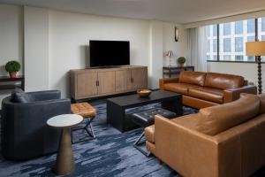 a living room with leather furniture and a flat screen tv at Fairfield Inn & Suites by Marriott Charlotte Uptown in Charlotte