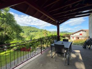 a table and chairs on a balcony with a view at La maison d'Artzamendi in Louhossoa