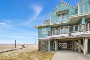 a blue house with a deck on the beach at CAC-3A - Clownfish in Buxton