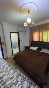 a bedroom with a large bed and a window at شقة مفروشة in Ajloun