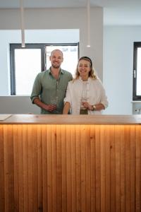 a man and a woman standing behind a wooden counter at Weingut Leininger Ferienwohnungen in Eibelstadt