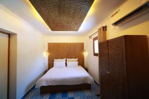 a bedroom with a white bed and a ceiling at Ahlan Riad Chefchaouen in Chefchaouen +59 photos