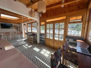 a room with chairs and a bar with windows at Ahlan Riad Chefchaouen in Chefchaouen